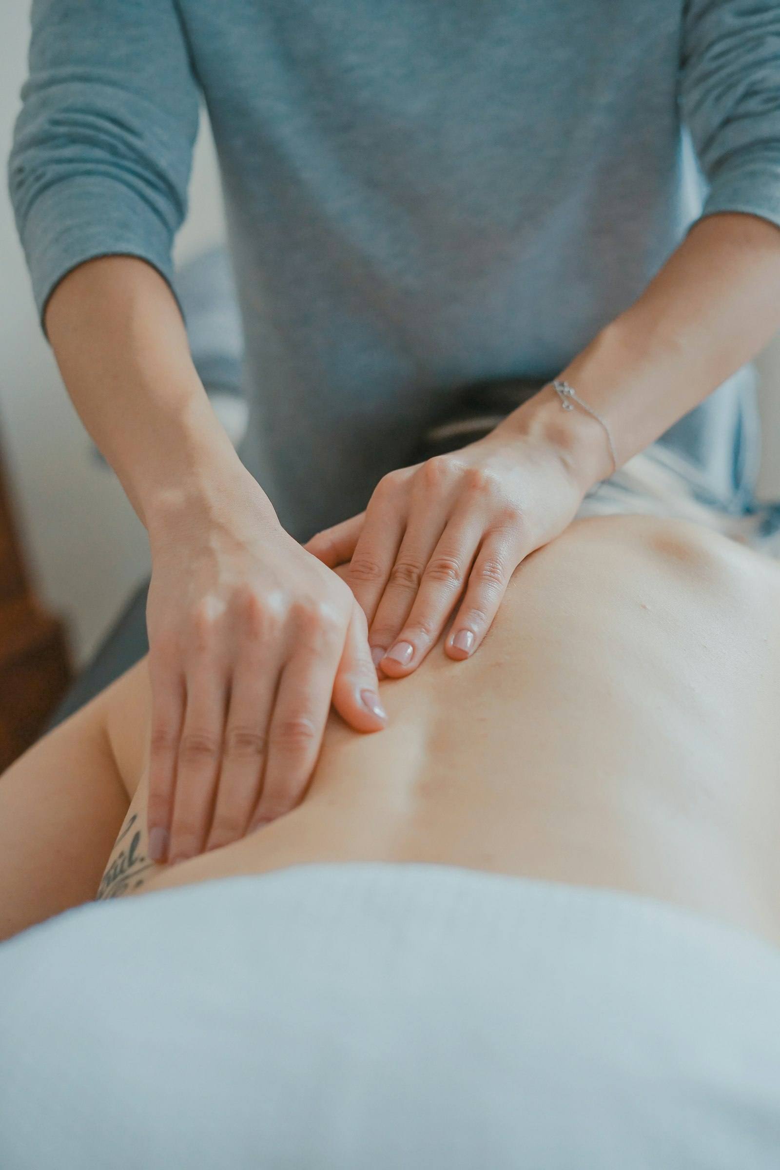 Therapist applying deep tissue massage to the back